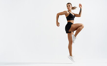 Fit Woman Exercising Outdoors. Healthy Young Female Athlete Doing Fitness Workout. Sportswoman Raising Leg, Do Functional Training Isolated White Background, Look Determined At Mockup