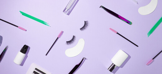 tools for eyelash extension on a lilac background. artificial eyelashes, self-care. tweezers, glue, 