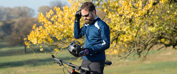 Conquering mountain peaks by cyclist in shorts and jersey on a modern carbon hardtail bike with an air suspension fork .