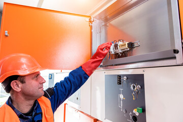 Canvas Print - The engineer checks the absence of induced voltage on the high voltage cells