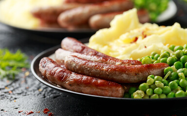 Pork Chipolata sausages with home cooked mashed potato and green peas