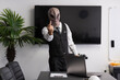 © Sabrina Umansky - Man wearing a mask of an alien looking at camera and showing middle finger in the office. Aggressive a humanoid alien businessman shows the camera a middle finger gesture up. Selective focus on hand