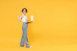Full length side view young freelancer fun woman 20s wear white tank top shirt using laptop pc computer chat online browsing internet walk do winner gesture clench fist isolated on yellow background.