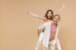Young parent man have fun with child teen girl incasual pastel clothes Dad little kid daughter giving piggyback ride to joyful, sit on back do flying gesture clench fist isolated on beige background.