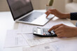 © fizkes - Crop close up of Indian woman manage household expenses expenditures calculate on machine pay on computer online. Ethnic female make web payment consider budget finances at home. Banking concept.