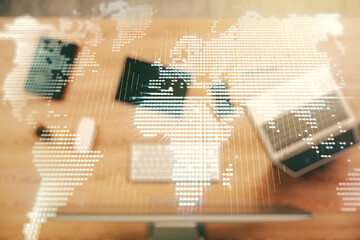 Abstract creative world map on modern laptop background, international trading concept. Multiexposure