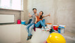 © My Ocean studio - Modern happy young couple in love in casual clothes during new home repair or renovation of walls with a lot of tools for this