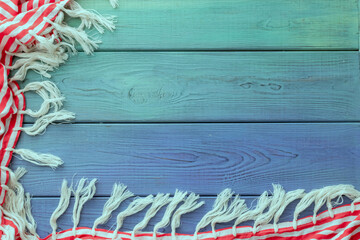 summer background: fringed pareos on a blue wooden background