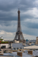 Wall Mural - Paris, the Eiffel Tower, beautiful monument, and typical roofs, stormy weather
