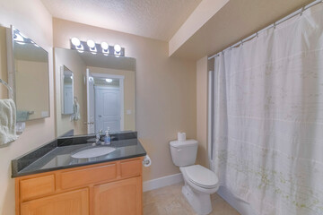 Sticker - Bathtub with a closed curtain, sink with a drawer, flush toilet and a big mirror in a bathroom