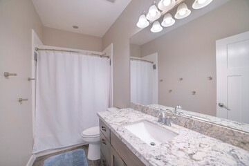 Sticker - Bathtub with a closed curtain, sink with a drawer and a big mirror in a modern bathroom