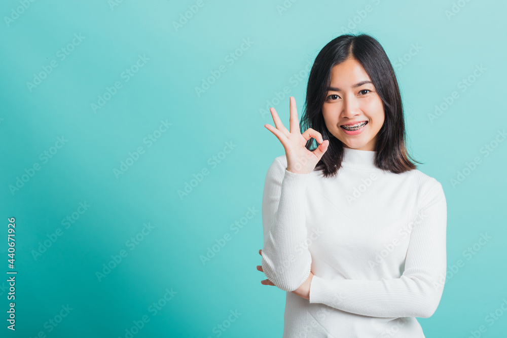 Young beautiful Asian woman smiling and showing hand the OK sign ...
