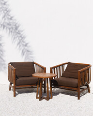 Vintage wooden chair over white wall with tropical shadow leaf.