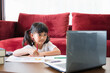 © FAMILY STOCK - Asian girl student online learning class study online with laptop at home.