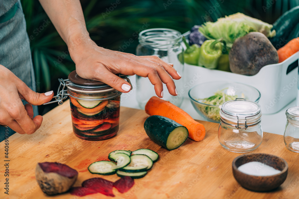 Woman Holding a Jar with Fermented Vegetables. - obrazy, fototapety, plakaty 