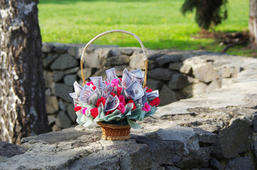 Wall Mural - Basket with paper roses and one hundred dollar bills. A gift for a financier.