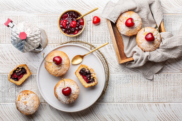 Wall Mural - Breakfast with coffee and homemade mini pies with cherry and blackcurrant feeling. Baked in a Muffin Tin. White wood background. Top view.