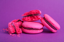 Delicious pink macarons on purple background, closeup