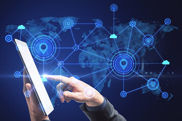 Poster - Hand using tablet with abstract map and location pins hologram on blue background. Geolocation and globalization concept.