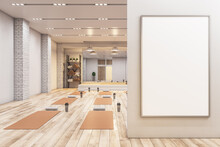 Modern Concrete Yoga Gym Interior With Equipment, Empty Billboard On Wall, Daylight And Wooden Flooring. Healthy Lifestyle Concept. Mock Up, 3D Rendering.