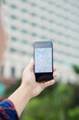 © DragonImages - Close-up of unrecognizable man using GPS navigation on smartphone against modern building while searching for place