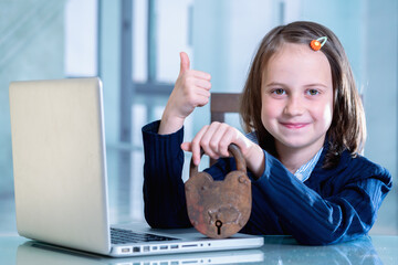 Concept of network security system and Internet data security. Humorous image of business child girl working with laptop and holding closed lock