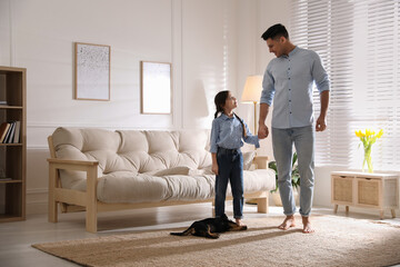 Sticker - Father and daughter with puppy near sofa in living room