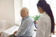 © Studio Romantic - Female doctor examining elderly male patient by stethoscope at hospital ward. Physician listening breath conducting lung test. Coronavirus flu medical checkup, old people medical health insurance
