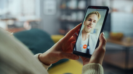 Fototapete - close up of a female chatting in a video call with her handsome caucasian male friend on smartphone 