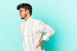 © Asier - Young caucasian man isolated on blue background suffering a back pain.