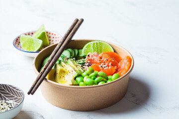 Wall Mural - Poke bowl with rice, salmon, edamame beans, cucumber and avocado in reusable cardboard bowl. Hawaiian food. Zero Waste concept.