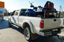 White Pick-up Truck Loaded With ATV Near Gas Station