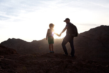 Wall Mural - Dad with son in the mountains in the desert