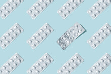 Pills Pattern. Composition Of Medical Silver Blisters With Pills And One Used On A Blue Background. Health Care Concept. Used Packaging From Vitamins. Pattern Made From Blister Packs Of Pills.