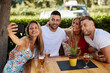 © djile - Group of young people having fun in a sumemer bar and taking selfie