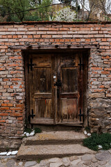 Sticker - Closeup shot of a wooden front door on a brick wall