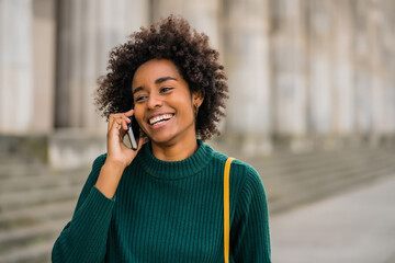 Wall Mural - Business woman talking on the phone outdoors.