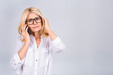 Middle age mature senior woman talking on smartphone isolated on white grey background stressed with hand on head, shocked with shame and surprise face, angry and frustrated.