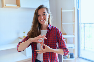 Portrait screen view of young smiling happy cute girl during online sign language courses at home using webcam conference on computer