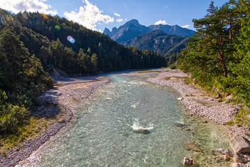 Wall Mural - Vibrant shot of the Isar river in Austria on background of mountains