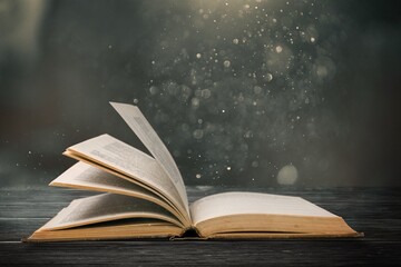 Wall Mural - magical open antique book over wooden table with glitter overlay