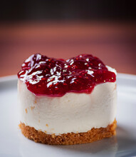 Detail Of A Raspberry Cheesecake On A White Plate With Blurred Background