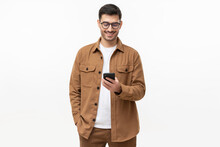 Smiling Man Wearing Casual Brown Shirt Looking At Phone, Isolated On Gray