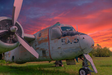 The Remains Of An Old Canadian War Plane Rest In A Field In A Museum At Sunset.