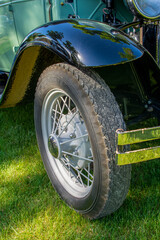 Wall Mural - Closeup shot of the right front side of a black-green retro car