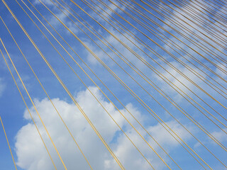 Wall Mural - big yellow sling cable of bridge with blue sky background