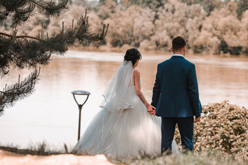 Canvas Print - Beautiful view of bride and groom walking into the garden