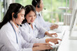 © SEVENNINE_79 - Asia medical service team health advice online. Smiling face stood wearing the headphones with a microphone and stethoscope in clinics.Concept of remote medicine, health care call center online.