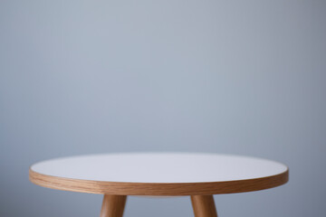 Background table. Round coffee table in the interior against the background of a light empty wall.