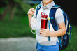 © Irina Schmidt - Closeup of kid boy, medical mask, water bottle and backpack or satchel. Schoolkid on way to school. child outdoors. Back to school after quarantine time from corona pandemic disease lockdown. no face.